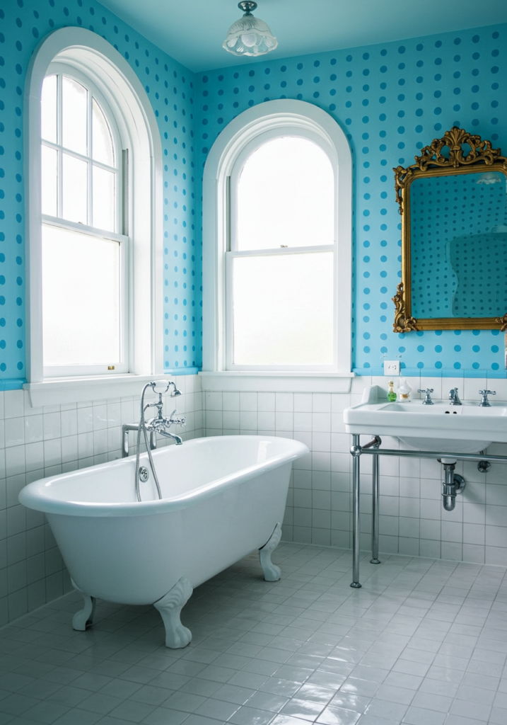 A bathroom with bright blue polka dot wallpaper and a white tiled floor.